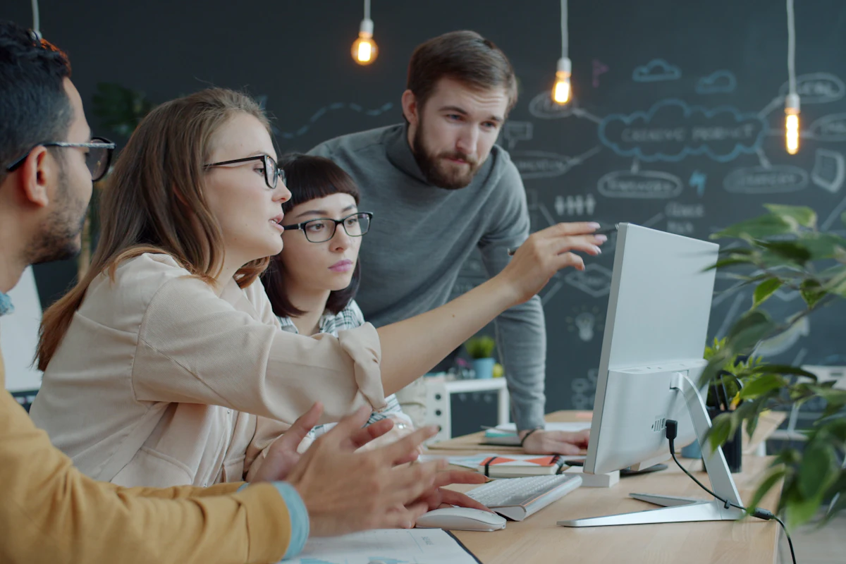 Equipo conversando alrededor de un computador